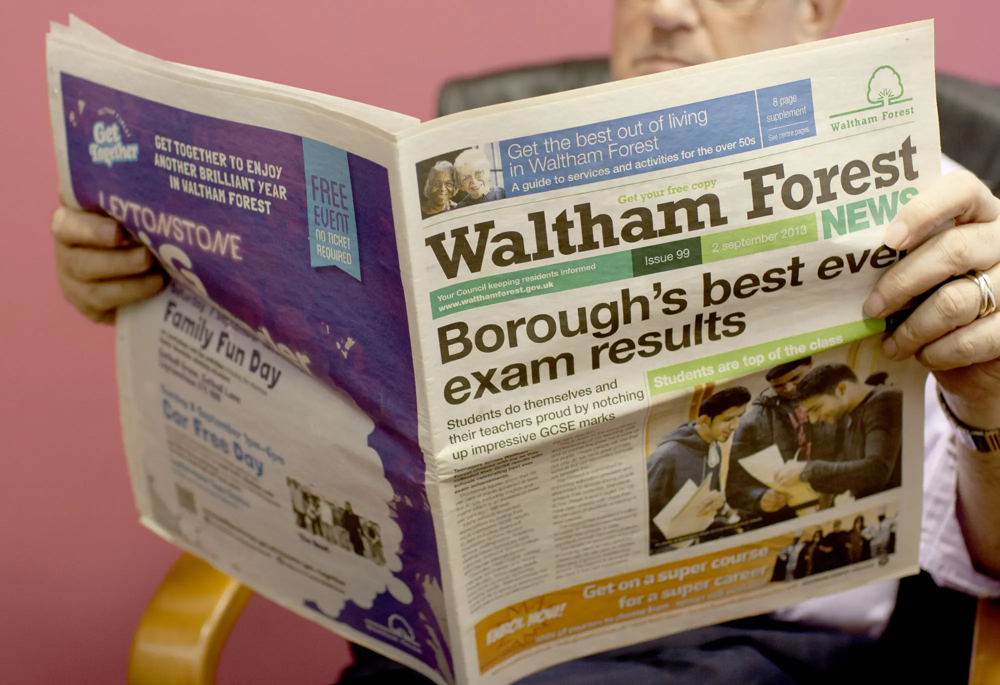 A person reading Waltham Forest News newspaper